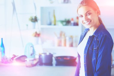 Mutfakta yemek hazırlayan genç bir kadın.