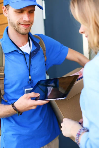 Uomo di consegna sorridente in uniforme blu che consegna pacchi al destinatario concetto di servizio di corriere. Uomo sorridente consegna in uniforme blu — Foto Stock