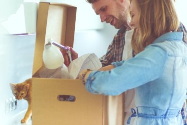 Genç bir çift yeni evde büyük karton kutu taşıyan. Ev taşıma. Genç Çift.