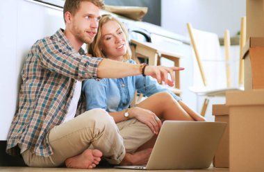 Genç bir çift yeni ev içinde hareket. Katta oturan ve açma sonra rahatlatıcı. Bir şey üstünde laptop arıyorum