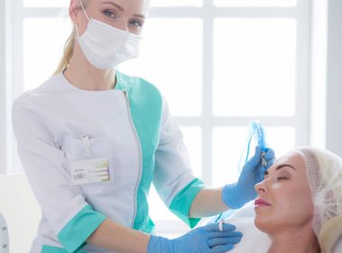 Kaşlar için kalıcı makyaj. Güzellik salonunda kalın kaşlı güzel bir kadın.