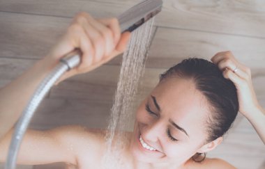 Genç beautyful kadın banyoda duş altında.