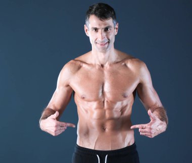 kaslı adam. Kaslı adam kas gösterilen gri arka plan üzerinde. Fitness Eğitmeni. Fitness profesyonel. Egzersiz. Mens fitness.