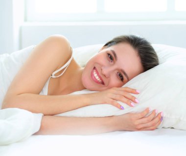 Güzel bir kadın yatağında uzanıyor.