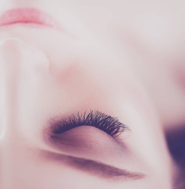 Masaj masasında uzanmış gözleri kapalı rahatlayan genç bir kadın. - Kadın. Spa salonu