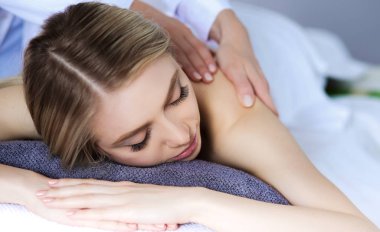 Masaj masasında uzanmış gözleri kapalı rahatlayan genç bir kadın. - Kadın. Spa salonu