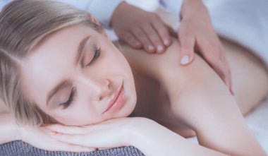 Masaj masasında uzanmış gözleri kapalı rahatlayan genç bir kadın. - Kadın. Spa salonu