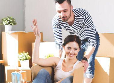 Açma veya kutu ambalaj ve yeni evine taşıdıktan mutlu genç bir çift. Genç Çift