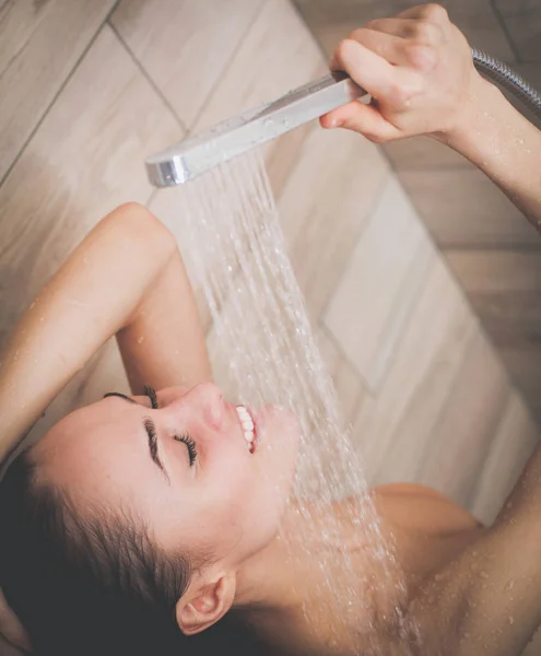 Jeune femme belle sous la douche dans la salle de bain . — Photo