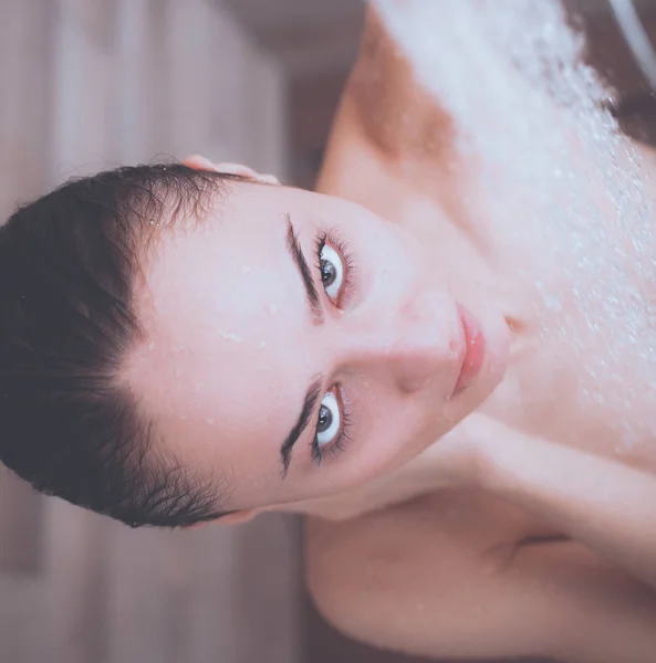 Ung, vakker kvinne under dusjen på badet. – stockfoto