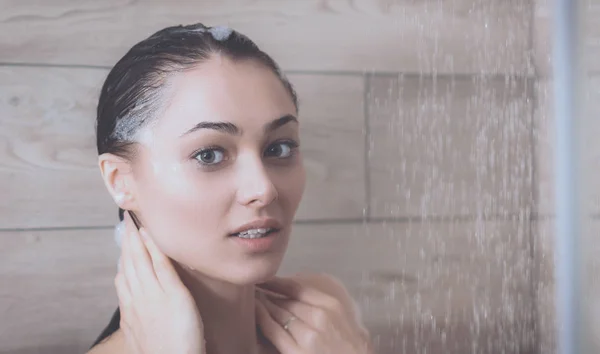 Jeune femme belle sous la douche dans la salle de bain . — Photo