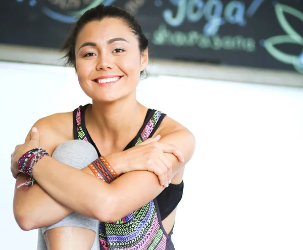 Портрет улыбающейся женщины-йоги, сидящей на коврике после тренировки в студии йоги. Йога. Женщина . — стоковое фото