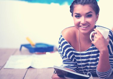 Duvar resmi yapıyor, merdiven üzerinde duran güzel ve genç birbayan. Güzel genç kadın