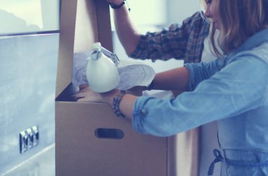 Genç bir çift yeni evde büyük karton kutu taşıyan. Ev taşıma. Genç Çift