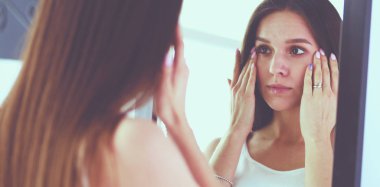 Genç kadın kendini evde aynada yansıma arıyor