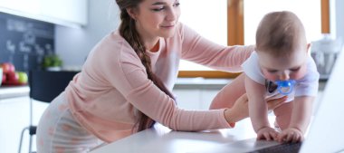 Annesi bebeğini evde parlak mutfakta ile.