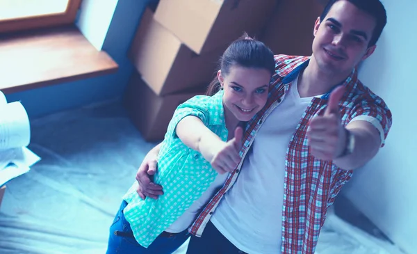 Genç Çift başparmak göstermek yukarıya onların yeni modern tasarım evinde mutlu