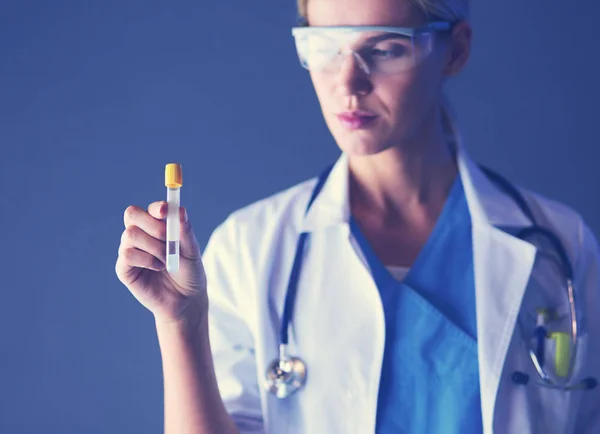 Female medical or research scientist or doctor using looking at a test tube of clear solution in a lab or laboratory. — Stock Photo, Image