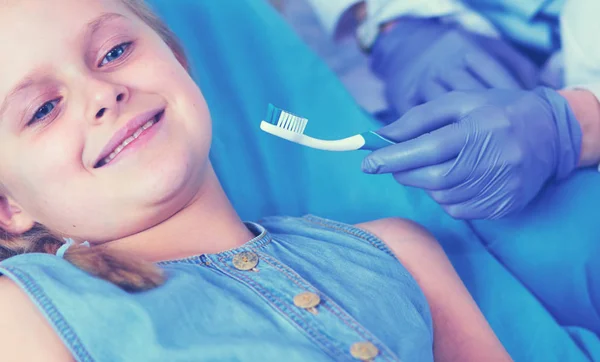 Niña sentada en el consultorio de dentistas. — Foto de Stock