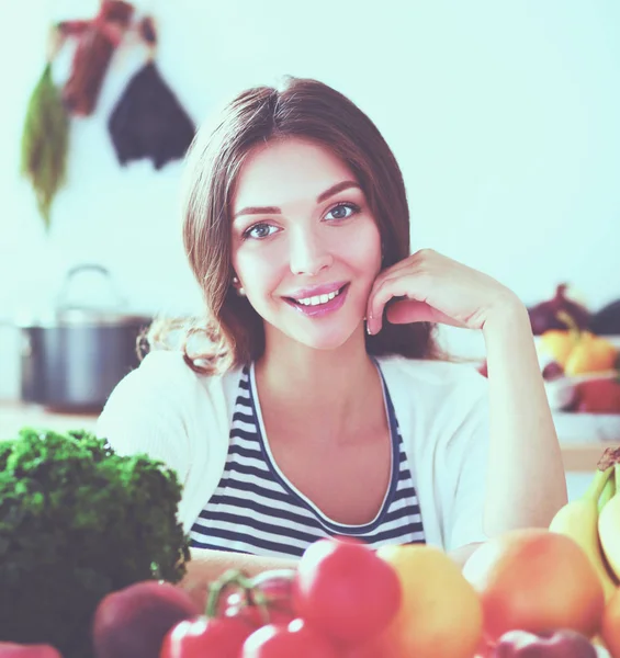 Jonge vrouw die bij een bureau in de keuken staat. Jonge vrouw . — Stockfoto