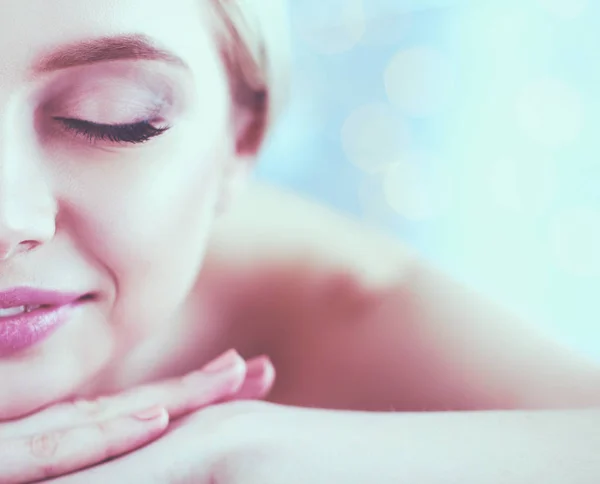 Mujer joven acostada en una mesa de masaje, relajándose con los ojos cerrados. Una mujer. Salón de spa — Foto de Stock