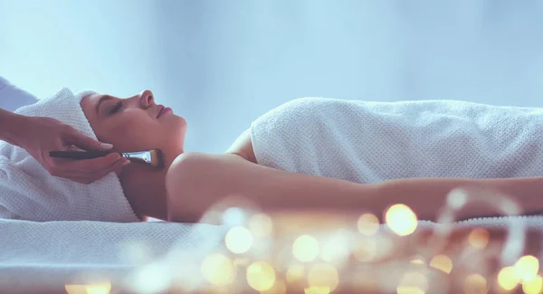 Jonge vrouw liggend op een massagetafel, ontspannend met gesloten ogen. Vrouw. Kuuroord — Stockfoto