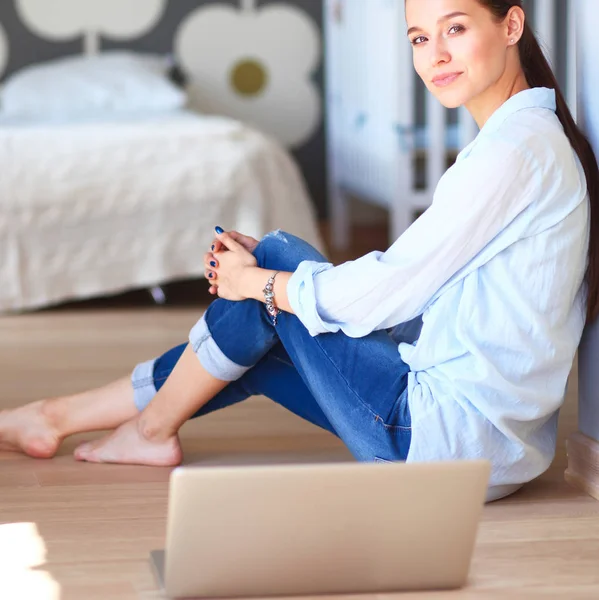 年轻漂亮的女人在家里坐在地上用的笔记本电脑 — 图库照片