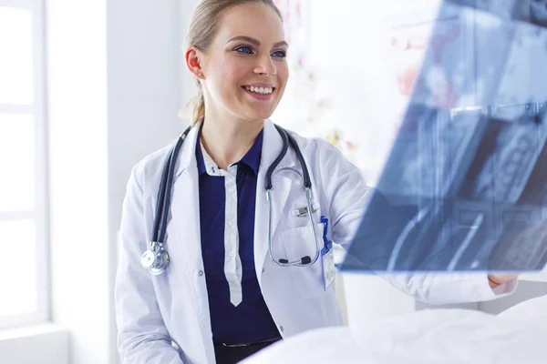 Молодая привлекательная женщина-врач смотрит на рентгеновское изображение — стоковое фото