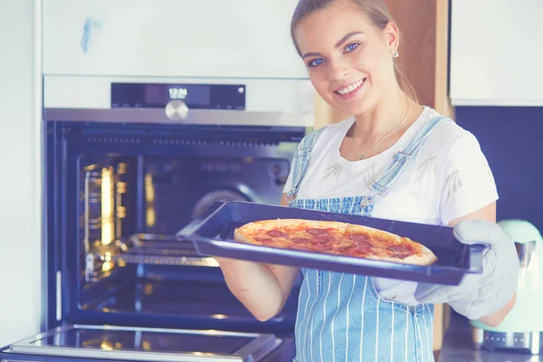 Gelukkig jong vrouw koken pizza thuis — Stockfoto