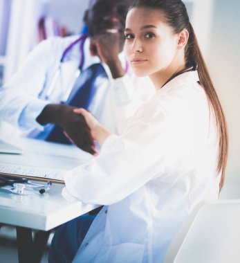 Ofiste tokalaşırken gülümseyen iki genç doktor.