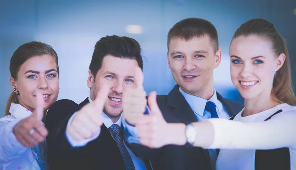 Feliz equipo de negocios mostrando pulgares hacia arriba en la oficina — Foto de Stock