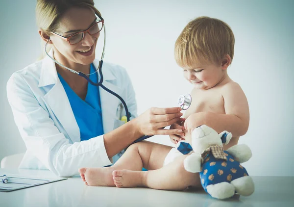 Female doctor is listening kid with a stethoscope in clinic — Stock Photo, Image