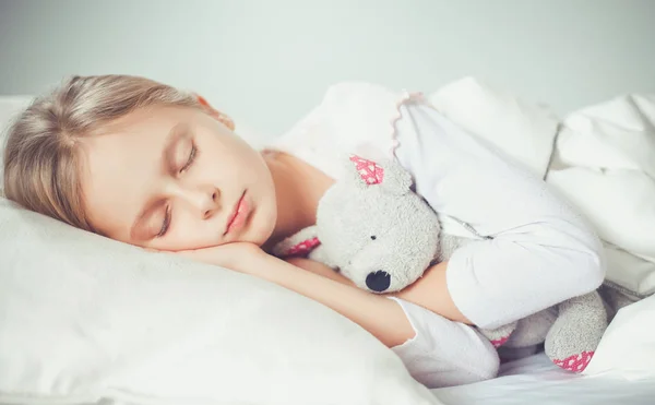 Niño niña duerme en la cama con un osito de peluche de juguete —  Fotos de Stock