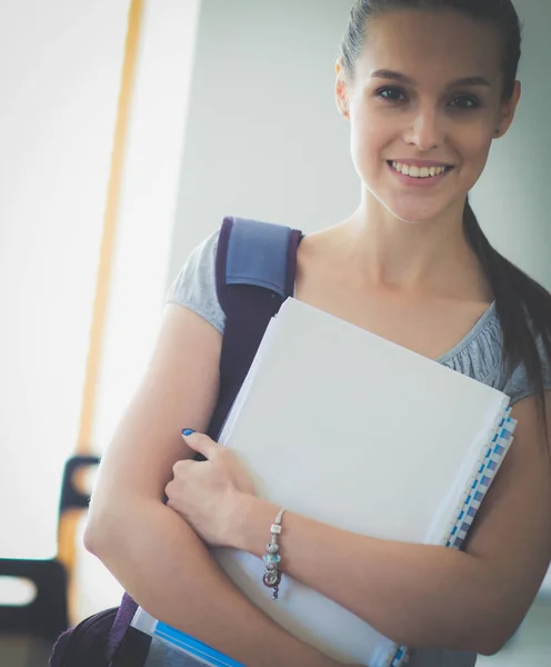 Retrato de una joven estudiante sosteniendo libros de ejercicios. Estudiante mujer — Foto de Stock