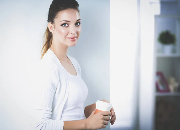 Attraktive junge Geschäftsfrau steht an Wand im Büro — Stockfoto