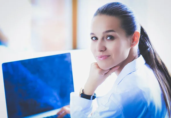 Bella giovane sorridente medico femminile seduto alla scrivania — Foto Stock