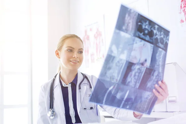 Giovane attraente medico femminile guardando l'immagine a raggi X — Foto Stock