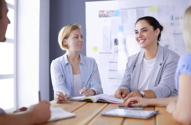 Masada kitaplarla çalışan gençler. Güzel kadınlar ve erkekler birlikte çalışıyor..