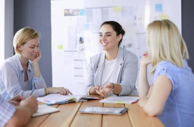 Masada kitaplarla çalışan gençler. Güzel kadınlar ve erkekler birlikte çalışıyor..