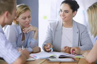 Masada kitaplarla çalışan gençler. Güzel kadınlar ve erkekler birlikte çalışıyor..