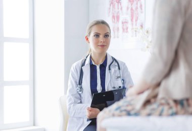 Doktor ve hasta masada otururken bir şey tartışıyorlar. İlaç ve sağlık hizmetleri kavramı