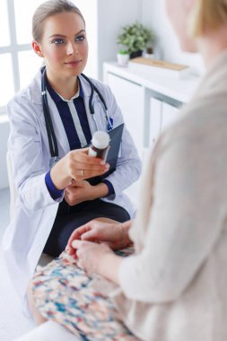 Doktor ve hasta masada otururken bir şey tartışıyorlar. İlaç ve sağlık hizmetleri kavramı