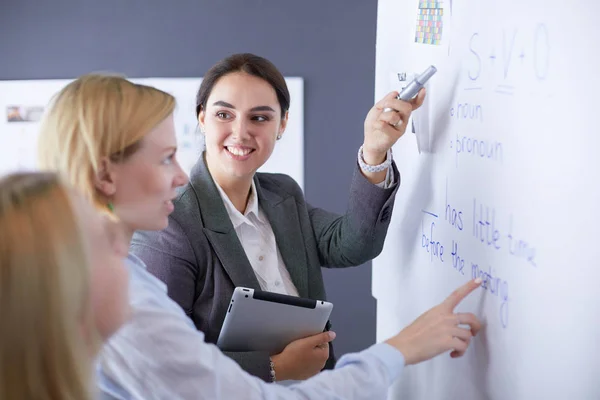 Business, education and office concept - business team with flip board in office discussing something. — Stock Photo, Image