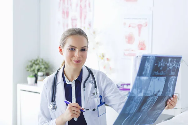 Giovane attraente medico femminile guardando l'immagine a raggi X — Foto Stock