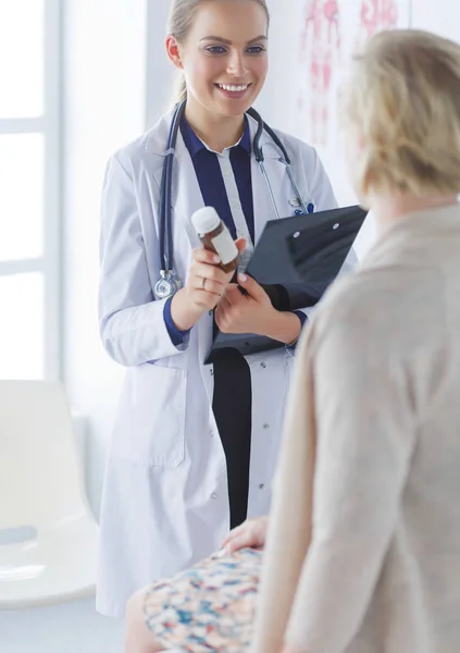 Doctor y paciente discutiendo algo mientras están sentados en la mesa. Concepto de medicina y salud — Foto de Stock