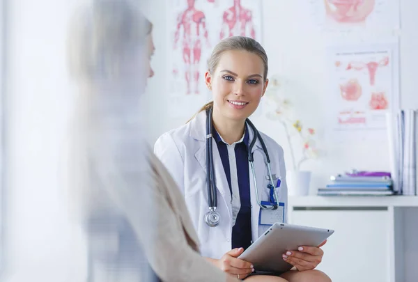 Dottore e paziente discutono di qualcosa mentre sono seduti al tavolo. Medicina e concetto di assistenza sanitaria — Foto Stock