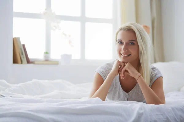 Mujer bonita acostada en su cama en casa — Foto de Stock