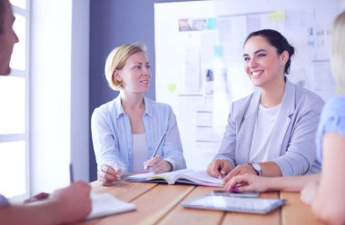 Masada kitaplarla çalışan gençler. Güzel kadınlar ve erkekler birlikte çalışıyor..