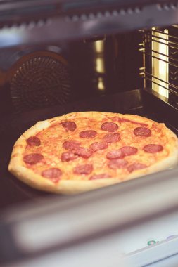 Mutlu genç bayan evde pizza pişiriyor.