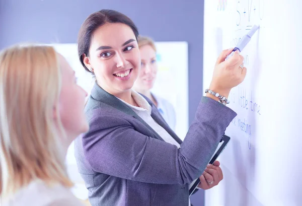 Business, education and office concept - business team with flip board in office discussing something. — Stock Photo, Image